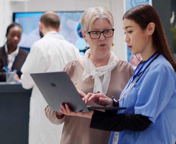 Nurses reviewing patient data on laptop — care management coordination