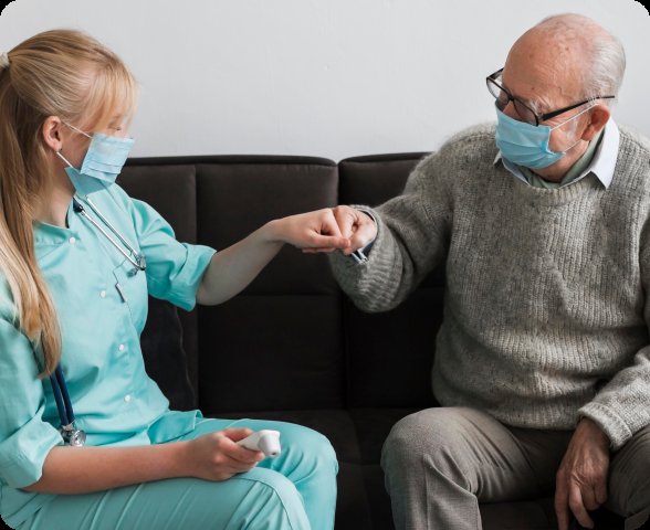 Nurse holding hands with elderly patient on couch — long-term care